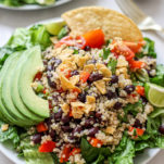 Quinoa Taco Salad with romaine quinoa, corn chips, veggies, lime avocado in bowl