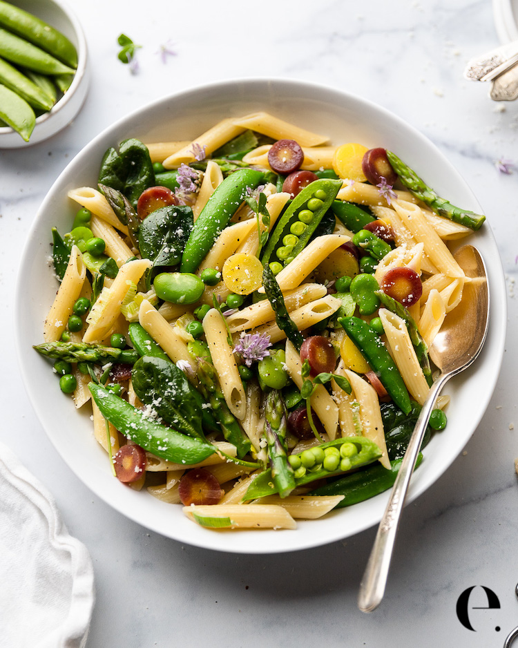 bowl of penne pasta with vegetables and parmesan cheese
