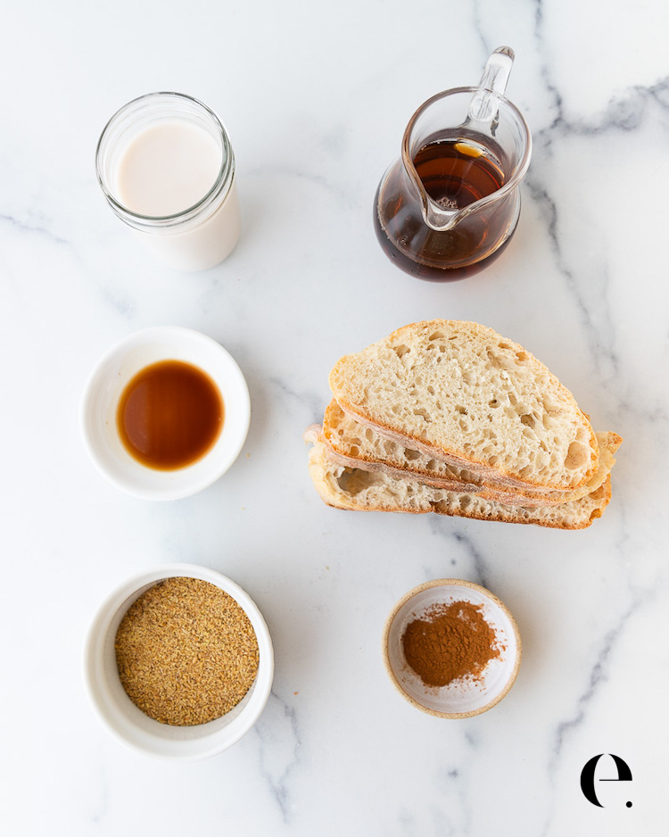 Vegan French toast ingredients: almond milk, maple syrup, vanilla extract, ground flax meal, cinnamon and sliced ciabatta bread