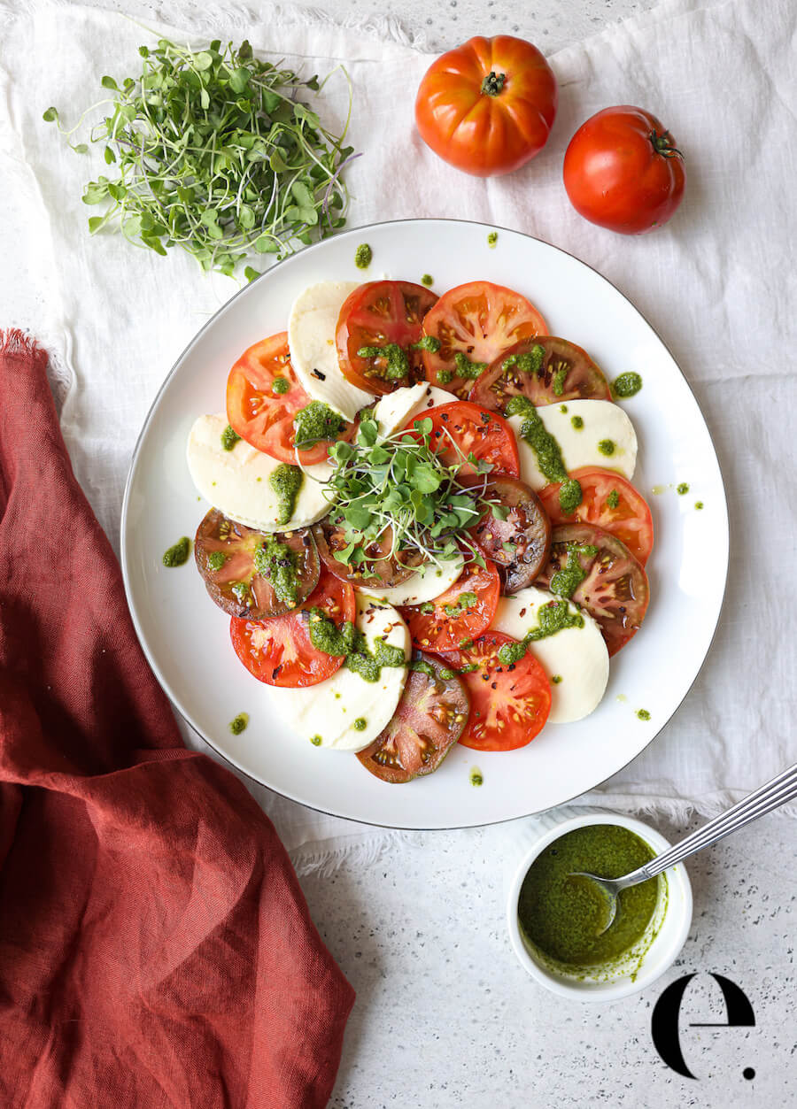 caprese salad on plate with pesto drizzle