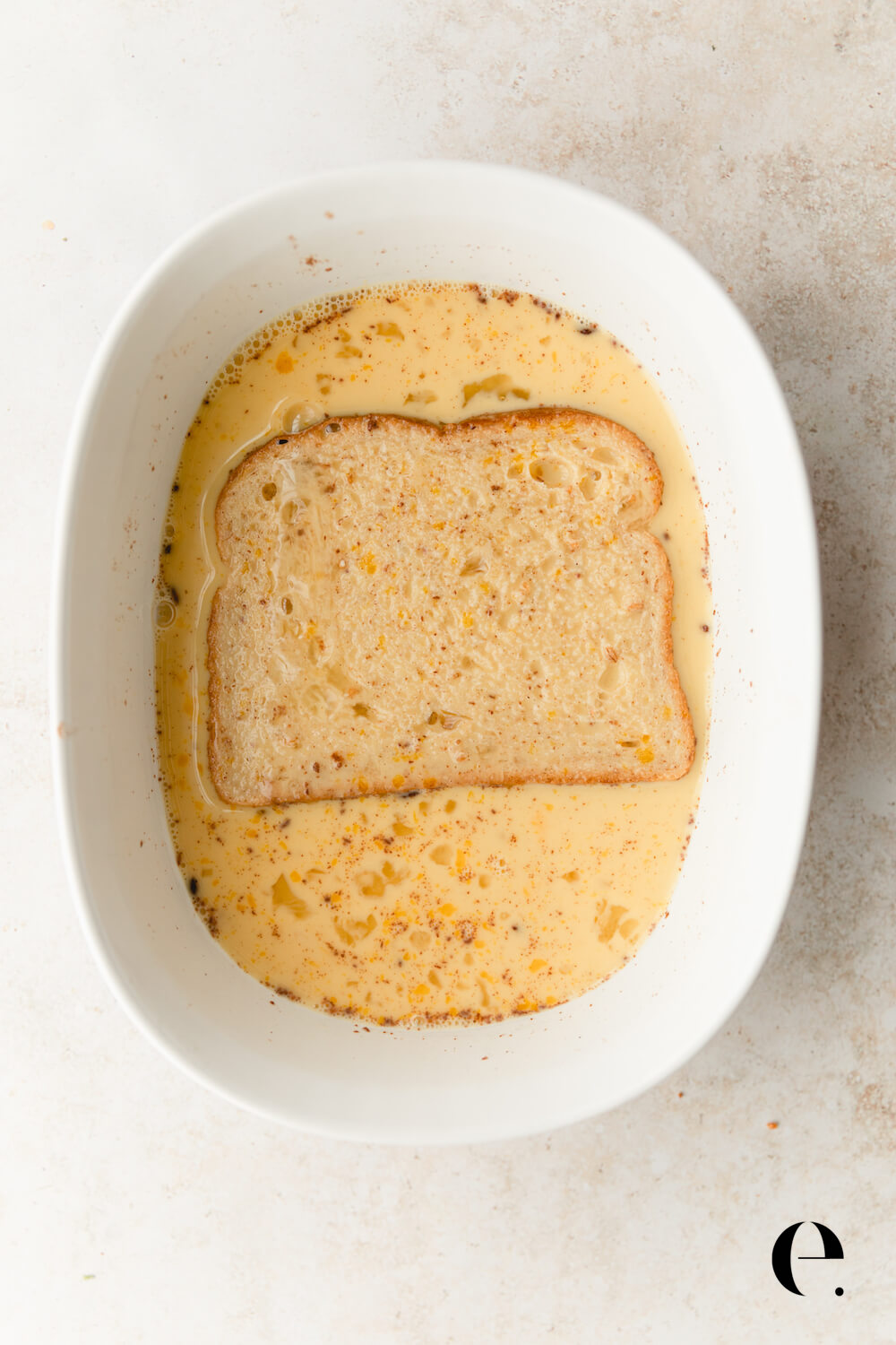 bread in custard in bowl for French toast by Elizabeth Rider