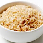 A bowl of fluffy cooked brown rice with tender, separated grains ready to serve.