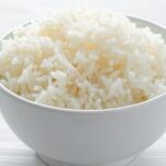 A bowl of fluffy white rice with a fork, showing perfectly cooked grains ready to serve.