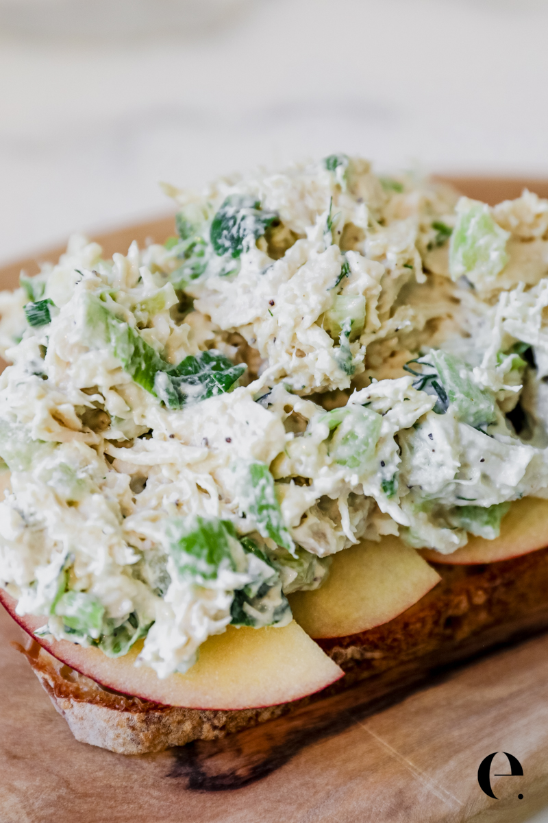 Open-face chicken salad sandwich with fresh dill and crisp apple slices on bakery bread