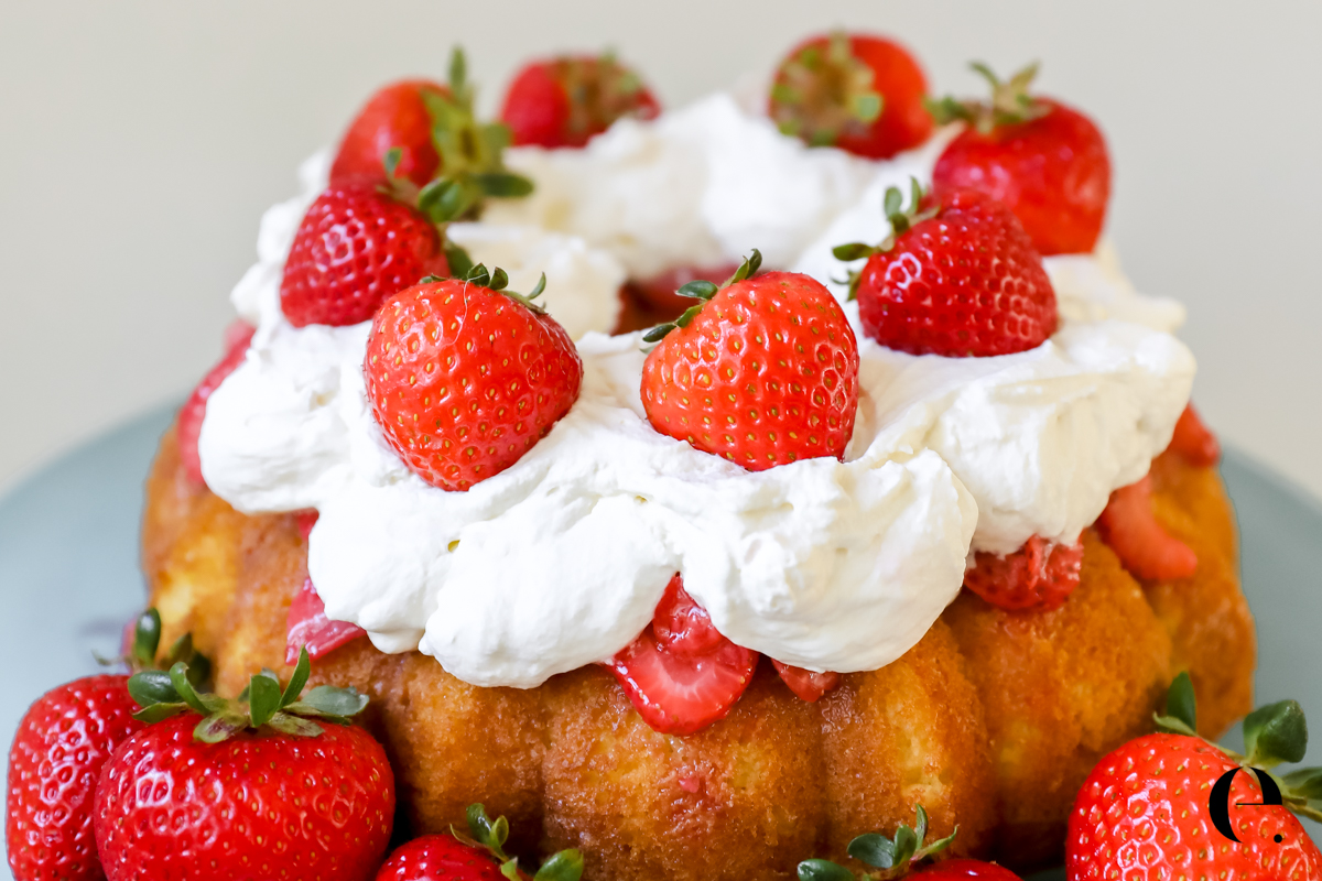 Strawberry Shortcake on cake stand with whipped cream and fresh strawberries