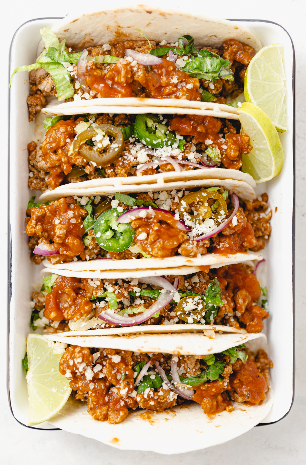 Ground Turkey Recipes including Taco Filling in Pan with tacos and lime wedges
