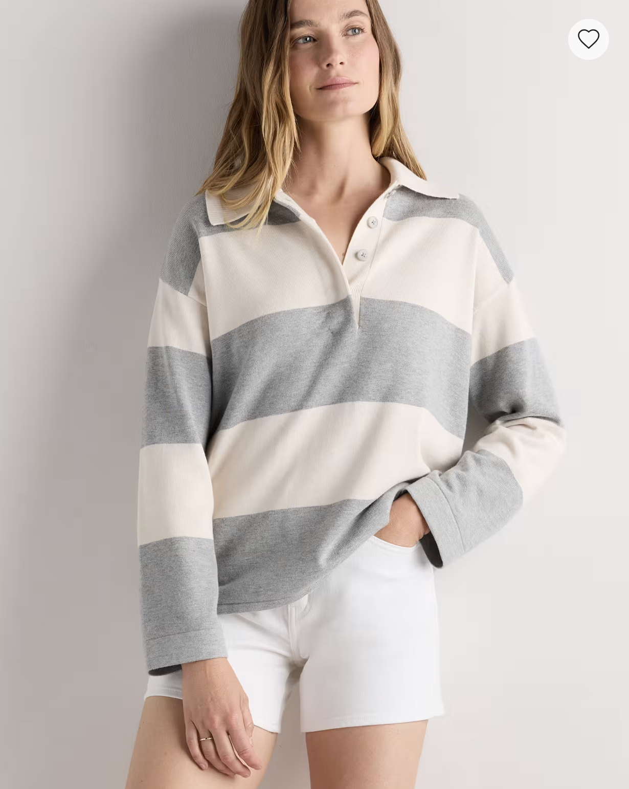 Model wearing the Quince Cotton Cashmere Rugby Polo Sweater in wide gray-and-ivory stripes with white shorts.