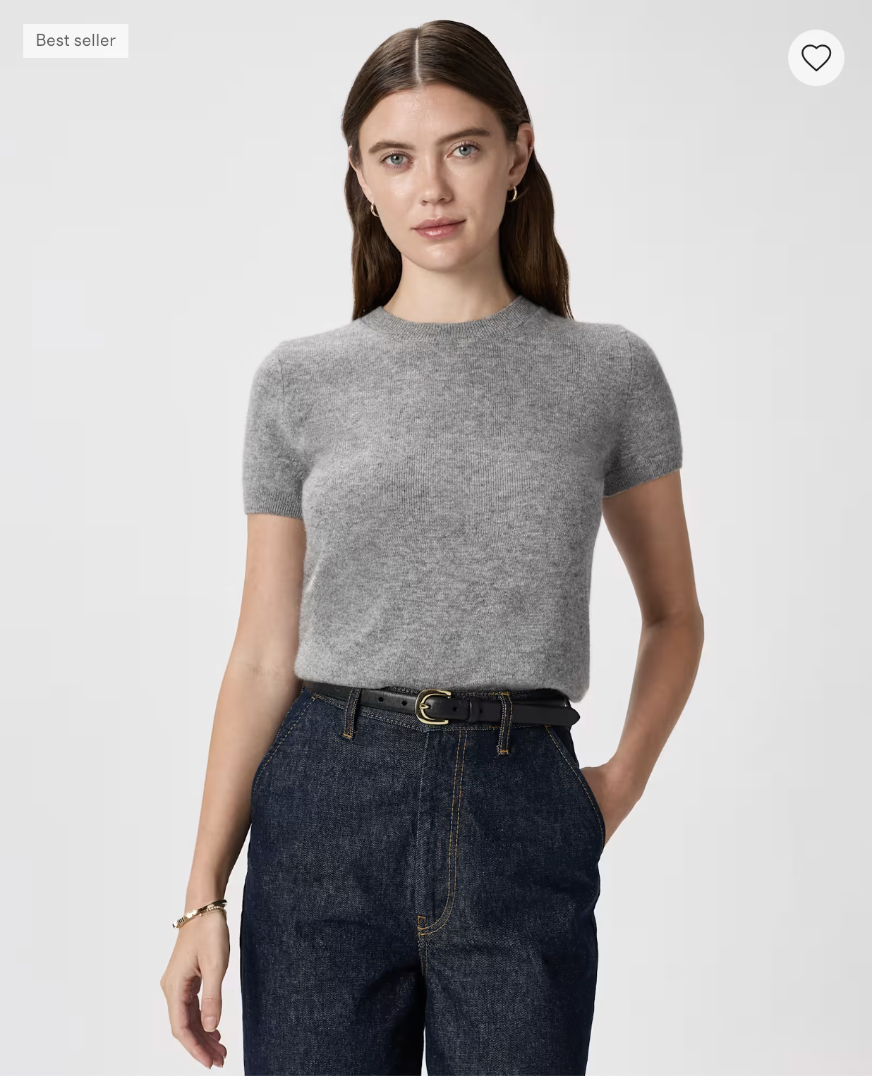 Model wearing the Quince Mongolian Cashmere Tee in heather gray, tucked into dark-wash jeans.