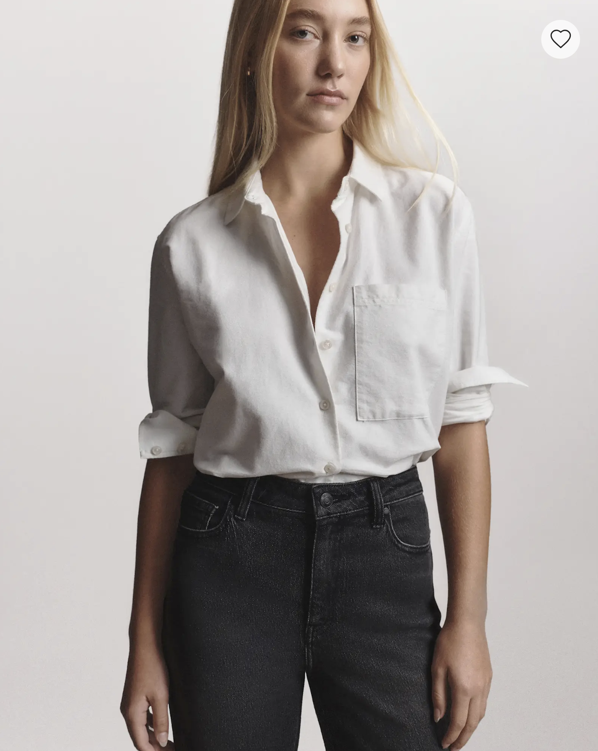 Model wearing the Quince Organic Cotton Relaxed Oxford Shirt in white with rolled sleeves and black jeans.