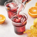 Tinto de verano poured into a tall glass of ice with an orange slice garnish