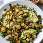 Quinoa bowl with roasted Brussels sprouts, crispy chickpeas, potatoes, kale and avocado, with a bowl of roasted chickpeas behind it