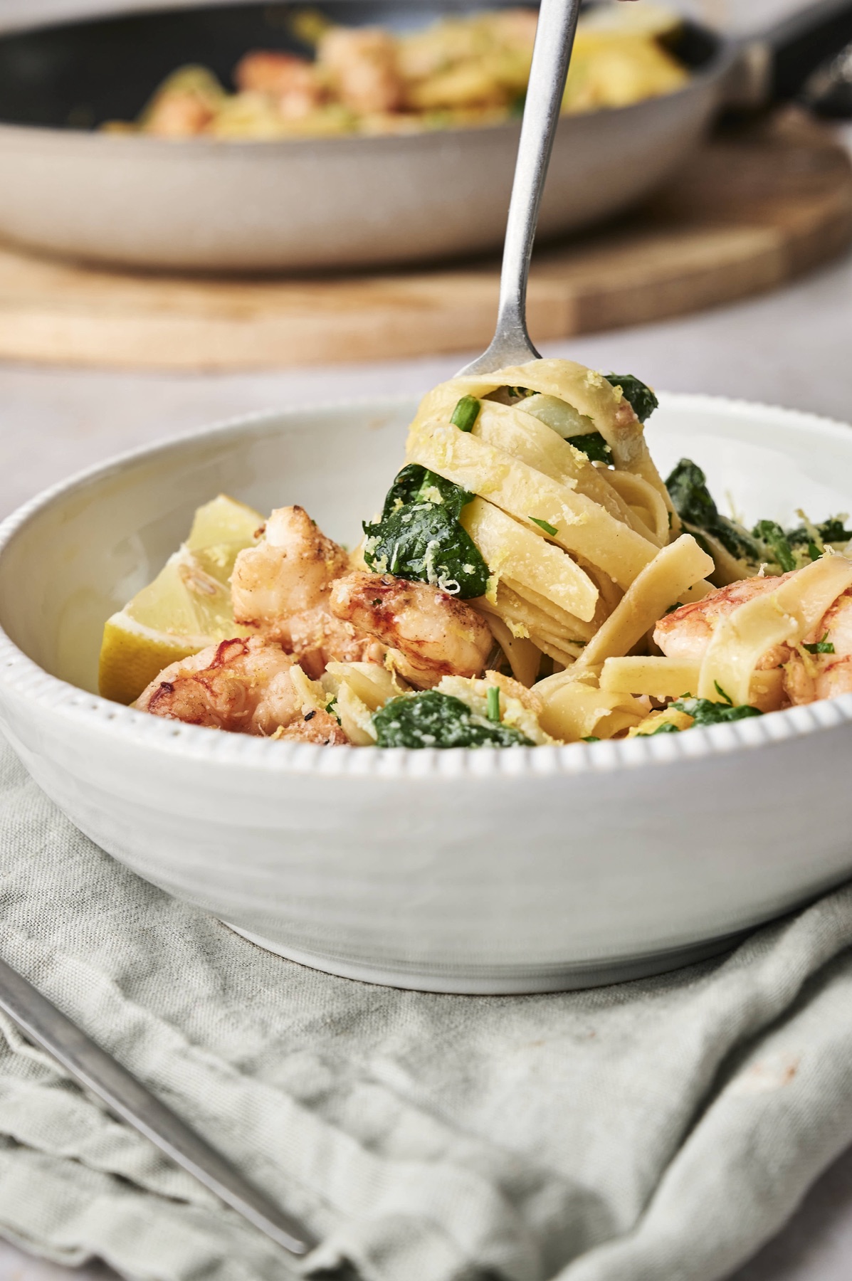 Twirling a forkful of shrimp pasta with spinach